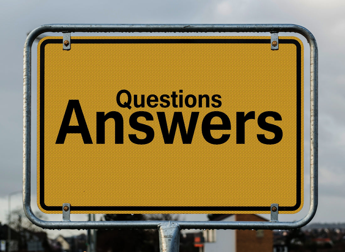 A photo of a bright yellow sign that says "Questions" in a medium font. Directly below "Questions" the word "Answers" is written in much larger letters. 